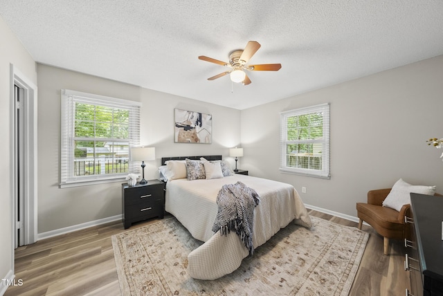 603 E Park St, Cary, NC 27511 - bedroom with multiple windows, light wood-type flooring, a textured ceiling, and ceiling fan