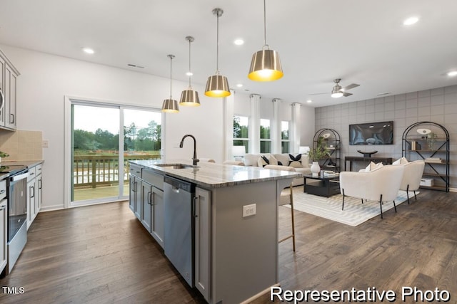 kitchen with sink, decorative light fixtures, a center island with sink, gray cabinets, and stainless steel appliances