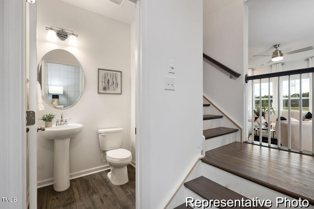 bathroom with wood-type flooring, sink, ceiling fan, and toilet