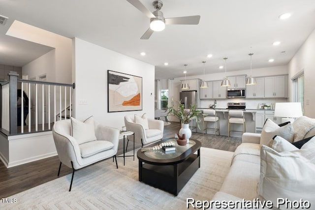 living room featuring ceiling fan and light wood-type flooring