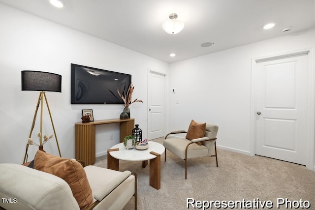 sitting room featuring light colored carpet