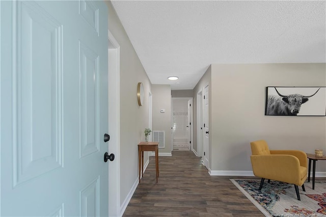 foyer featuring a textured ceiling and dark hardwood / wood-style floors