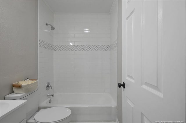 full bathroom featuring tiled shower / bath, crown molding, vanity, and toilet