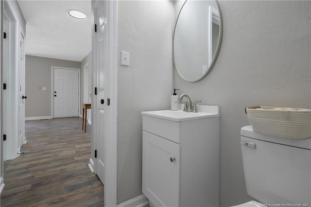 bathroom with vanity, toilet, and hardwood / wood-style flooring