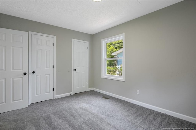 unfurnished bedroom featuring carpet and a textured ceiling