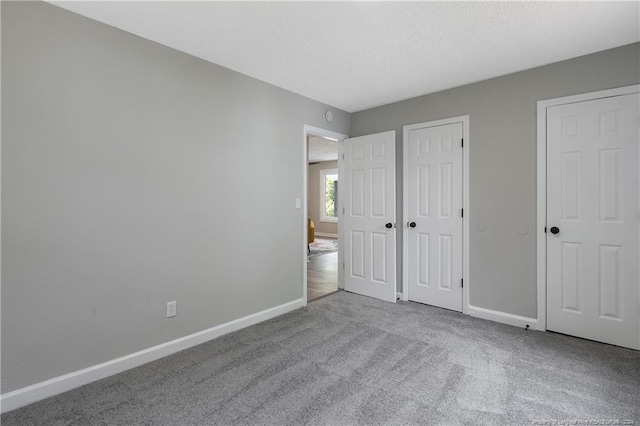 unfurnished bedroom with a textured ceiling and carpet