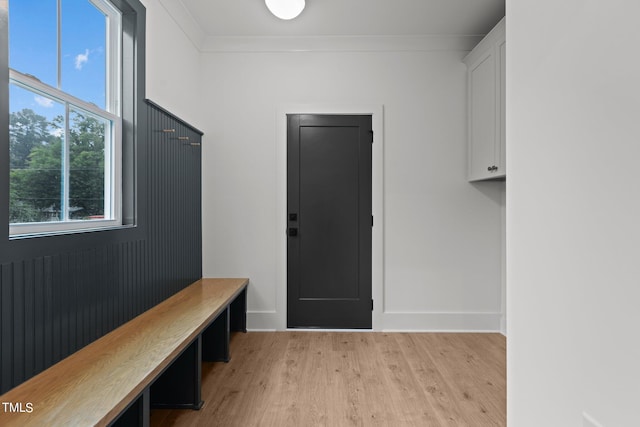 mudroom featuring ornamental molding, light wood-type flooring, and baseboards