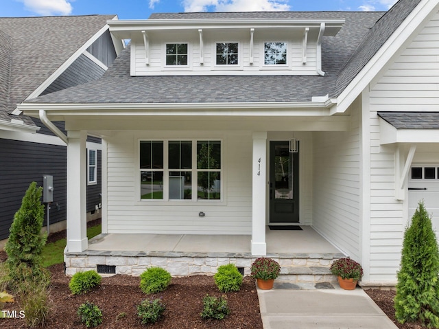 doorway to property featuring a garage and a porch