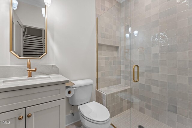 bathroom featuring vanity, toilet, and a shower with shower door