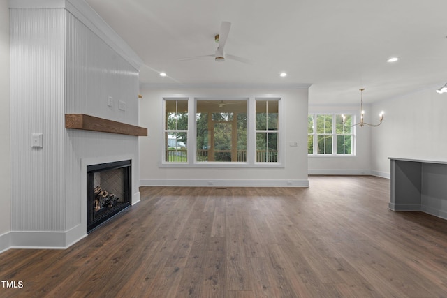 unfurnished living room featuring ceiling fan with notable chandelier, a fireplace, recessed lighting, and wood finished floors