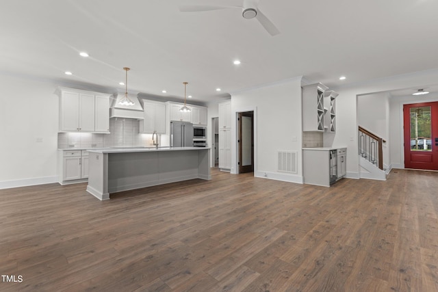 kitchen with pendant lighting, an island with sink, white cabinets, and dark hardwood / wood-style flooring