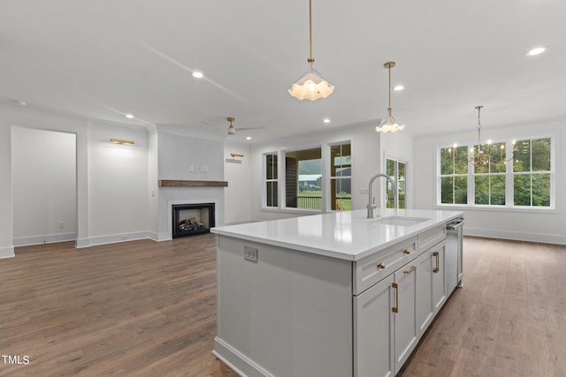 kitchen featuring dark wood-style floors, recessed lighting, a fireplace, and a sink