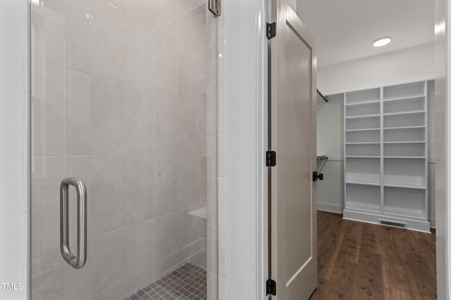 bathroom featuring a shower with shower door and hardwood / wood-style flooring