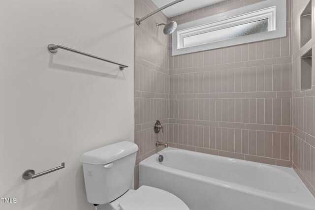 bathroom featuring tiled shower / bath and toilet