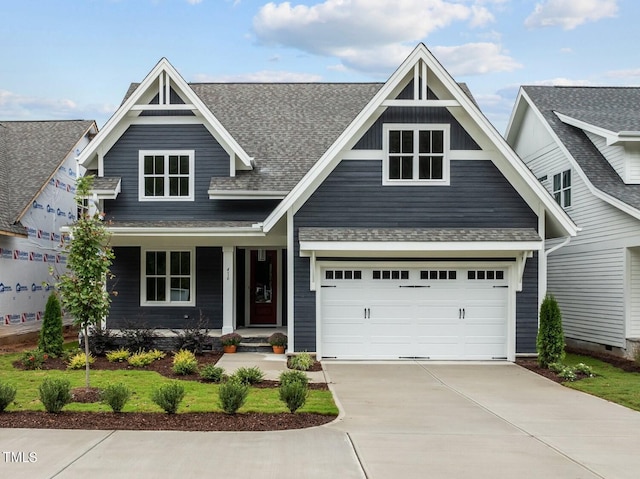 view of front of home featuring a garage, driveway, and a shingled roof