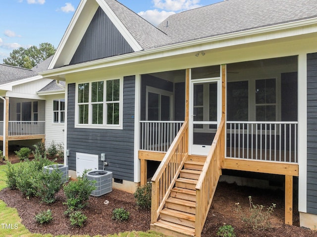 back of house with a shingled roof, a sunroom, stairs, and central air condition unit