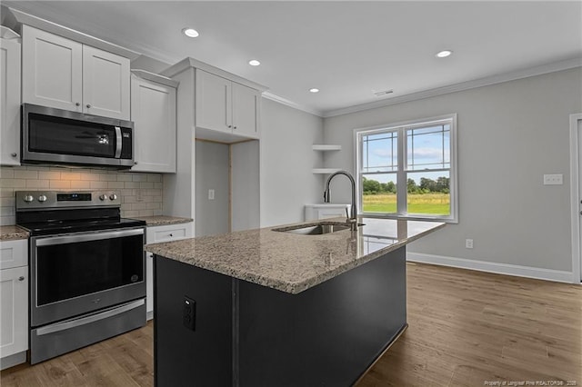 kitchen with a kitchen island with sink, stainless steel appliances, a sink, white cabinets, and crown molding