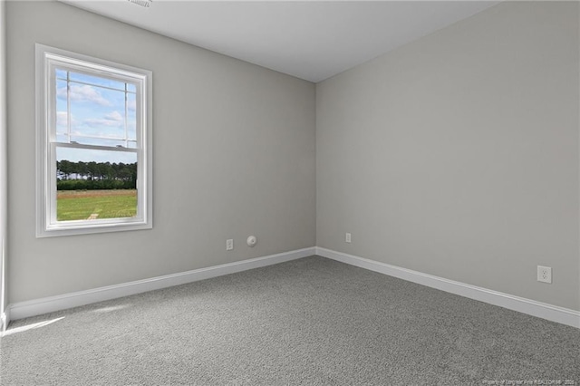 unfurnished room featuring carpet and baseboards