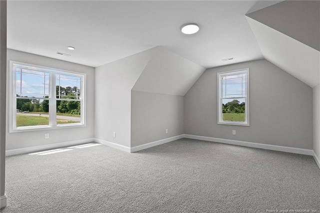 bonus room featuring lofted ceiling, carpet flooring, visible vents, and baseboards