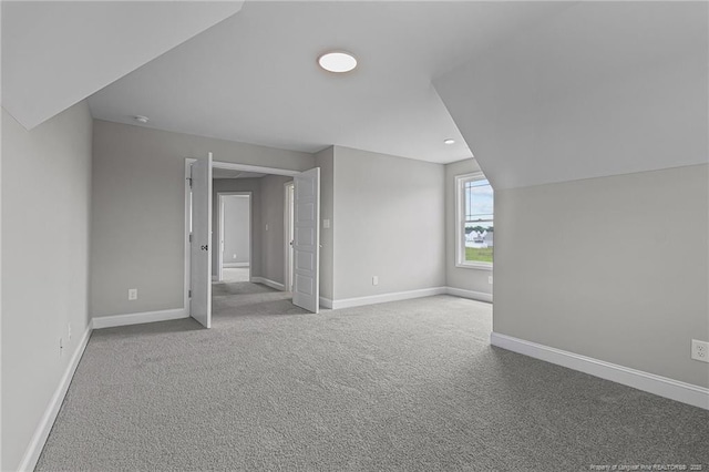 bonus room featuring light carpet and baseboards