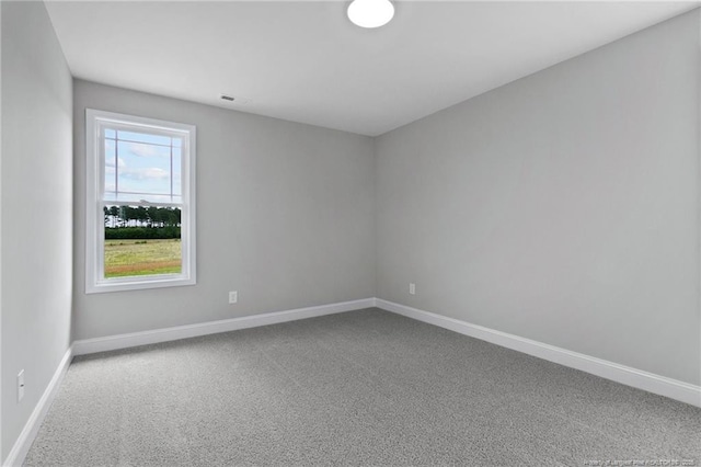 carpeted empty room featuring baseboards