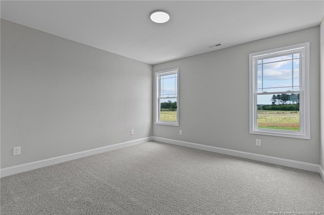 carpeted empty room featuring visible vents and baseboards