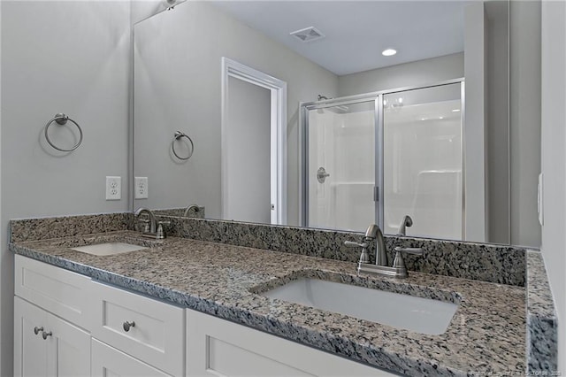 full bathroom featuring a stall shower, visible vents, a sink, and double vanity