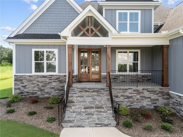 view of exterior entry with a porch and french doors