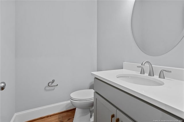 bathroom featuring hardwood / wood-style floors, vanity, and toilet