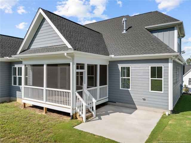 rear view of house with a yard, a patio, and a sunroom