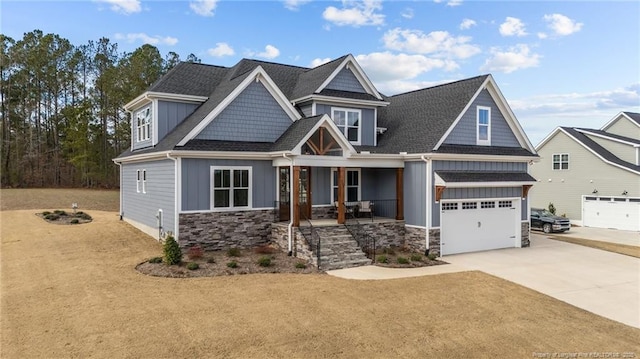 craftsman-style house featuring stone siding, a porch, board and batten siding, concrete driveway, and a garage