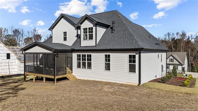 back of property with a yard and a sunroom