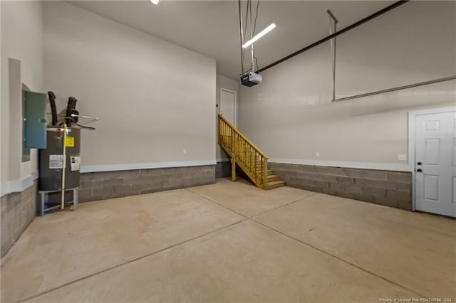 garage featuring electric panel, a garage door opener, and water heater