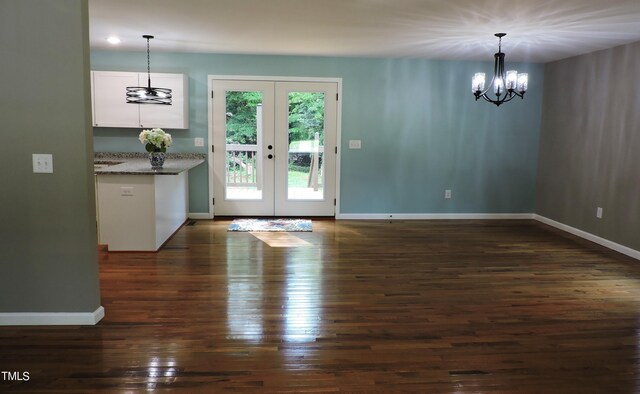 interior space featuring an inviting chandelier, dark hardwood / wood-style floors, and french doors