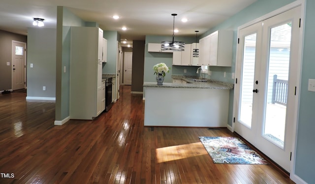 kitchen with dark hardwood / wood-style flooring, a wealth of natural light, white cabinetry, and light stone countertops