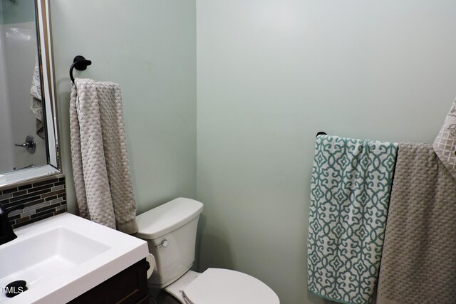 bathroom with vanity, backsplash, and toilet