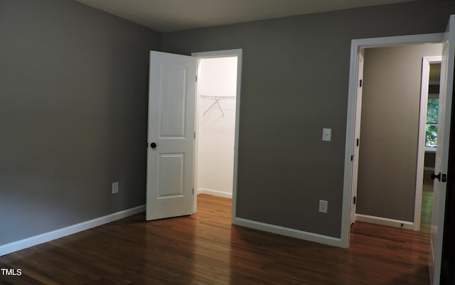 unfurnished bedroom featuring a closet, baseboards, and wood finished floors
