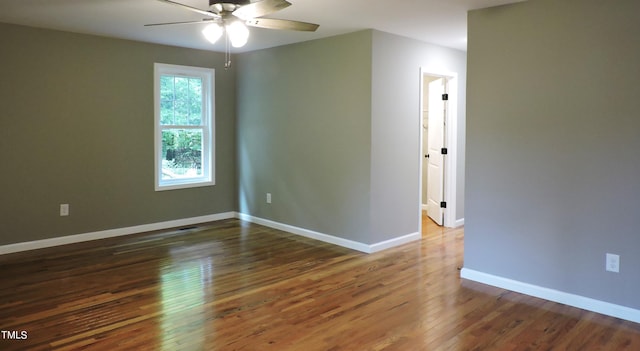 spare room with dark hardwood / wood-style flooring and ceiling fan