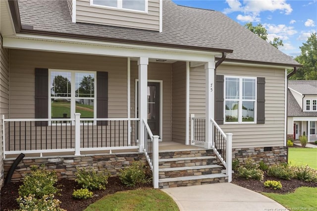 view of exterior entry with crawl space, roof with shingles, and a porch