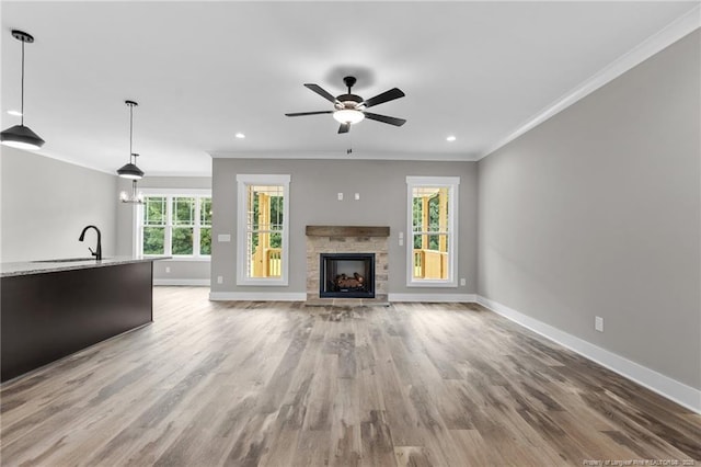 unfurnished living room featuring baseboards, a fireplace, and ornamental molding