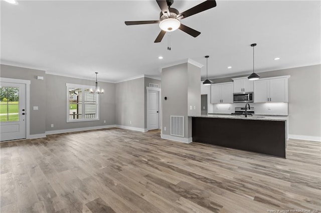 kitchen featuring a healthy amount of sunlight, appliances with stainless steel finishes, white cabinets, and open floor plan