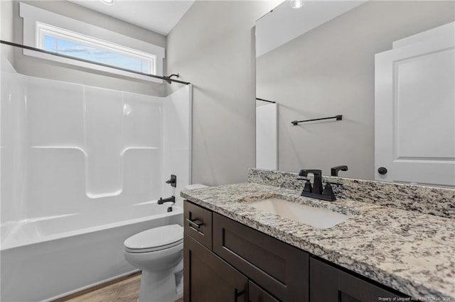 full bathroom featuring bathtub / shower combination, vanity, toilet, and wood finished floors