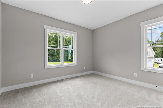 carpeted empty room featuring baseboards