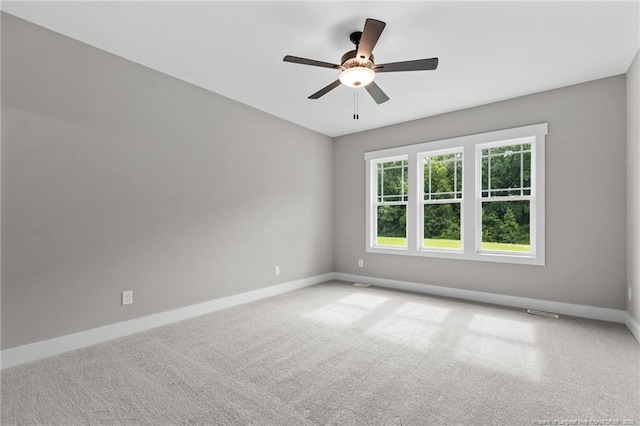 carpeted empty room featuring visible vents, baseboards, and a ceiling fan