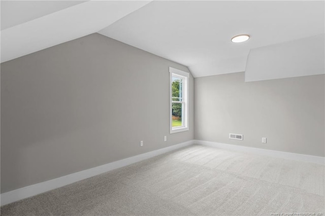 bonus room featuring lofted ceiling, carpet flooring, and baseboards