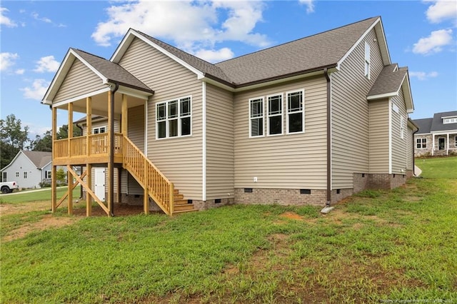 rear view of property with crawl space, a shingled roof, stairway, and a yard