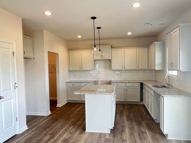 kitchen featuring hanging light fixtures, a center island, white cabinetry, sink, and dark wood-type flooring