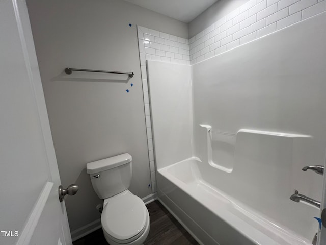 bathroom featuring hardwood / wood-style floors, tiled shower / bath, and toilet