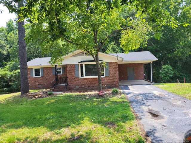 single story home featuring a carport and a front yard