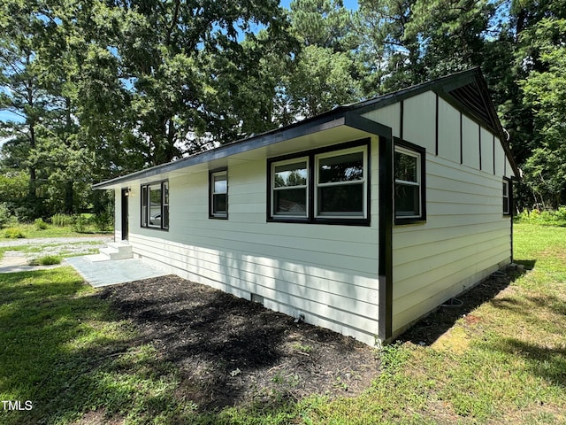 view of side of home with a lawn